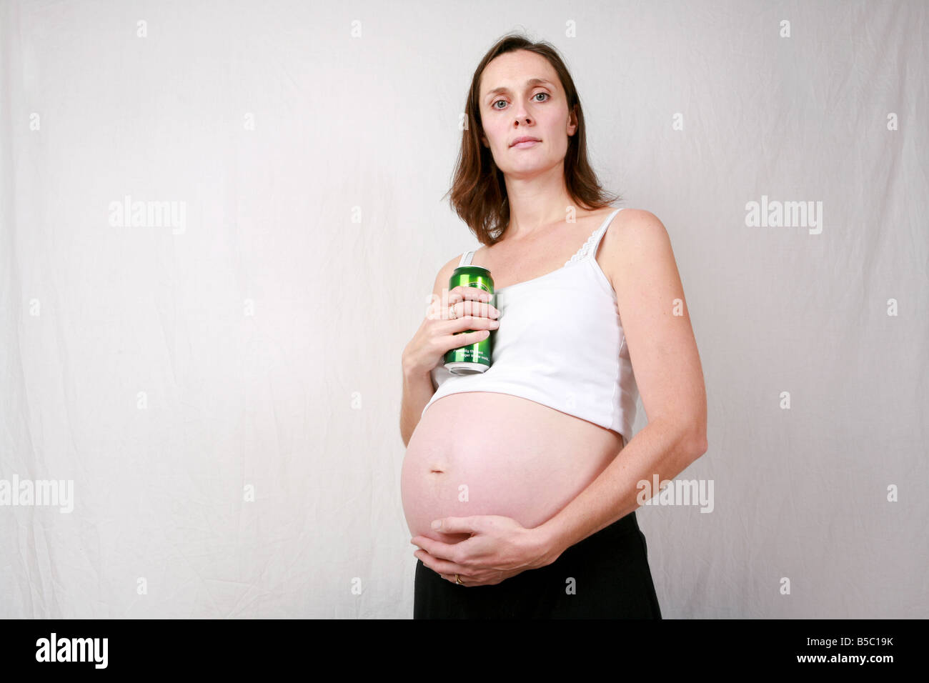 Heavily pregnant young woman in third trimester at 32 weeks drinking