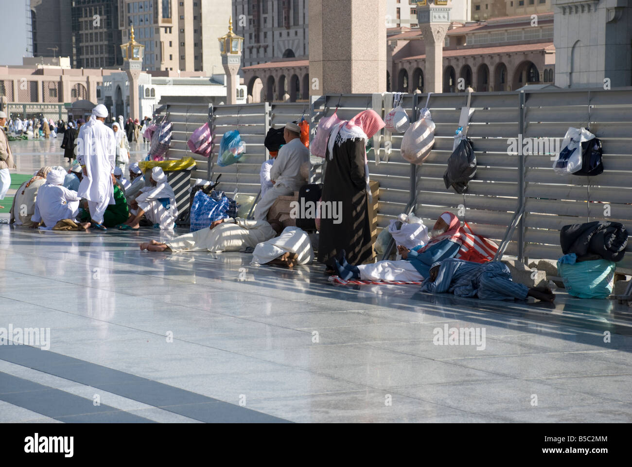 Some pilgrims sleep in the courtyaard of Masjid al Nabawi in Madinah and they tie their luggage to the fences Saudi Arabia Stock Photo
