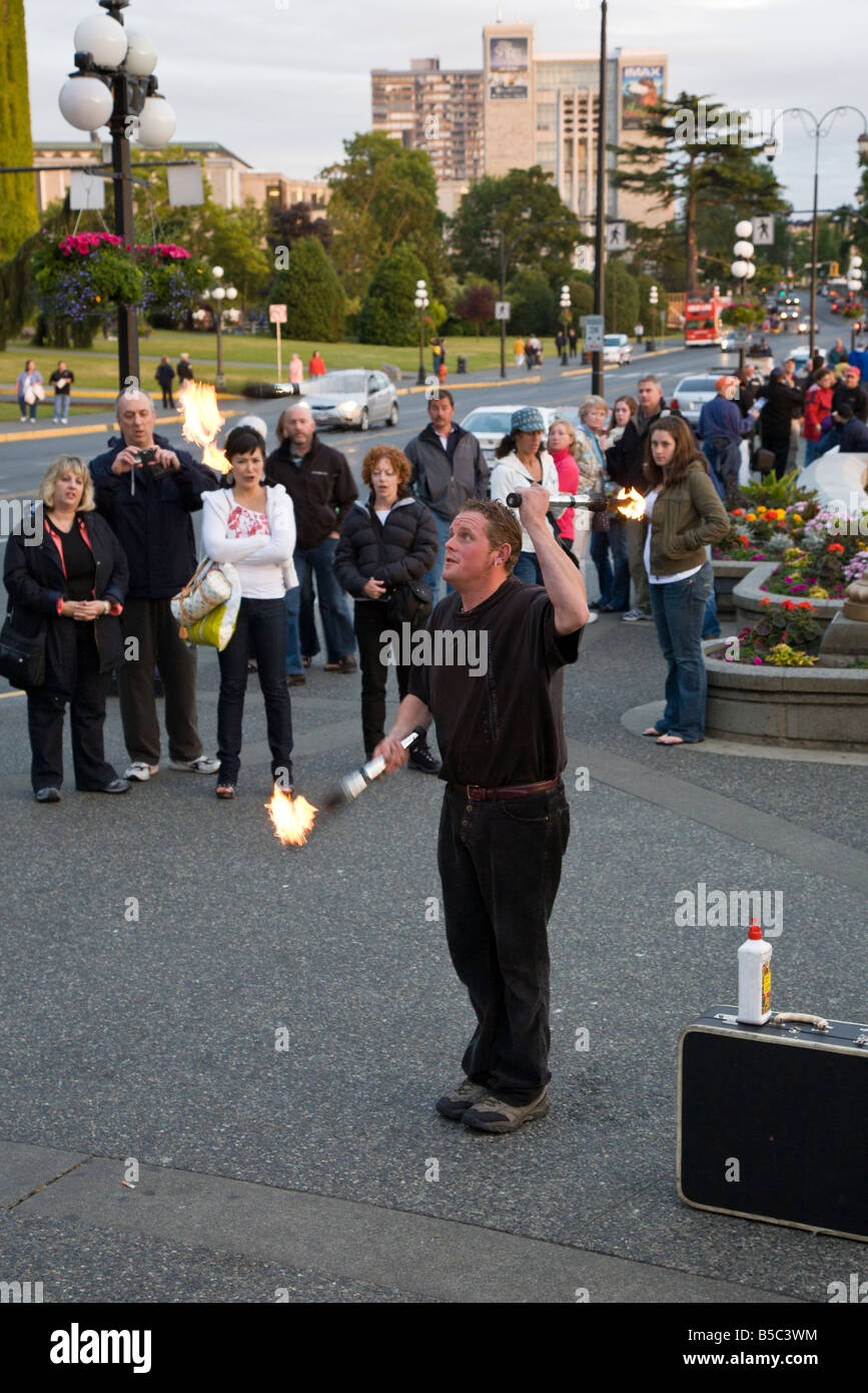 Street performer juggling fire in front of the Inner Harbour in Victoria, British Columbia, Canada Stock Photo