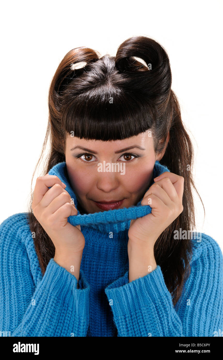 Young girl hiding her face under a long neck blue sweater Stock Photo