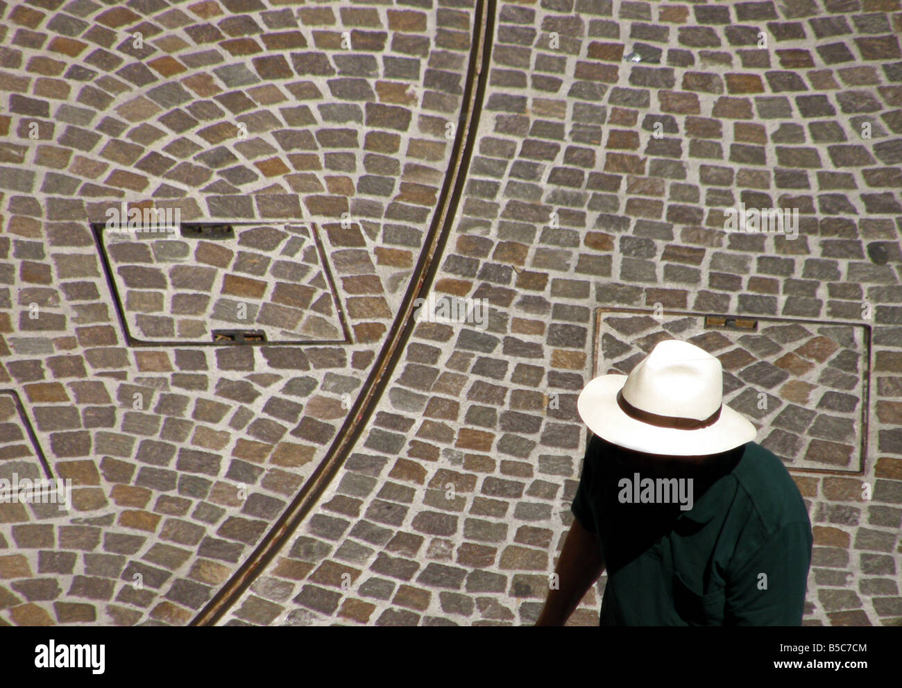anonymous tourist with panama hat in Sirmione, Lake Garda with face in shadow against background of patterned paving blocks Stock Photo
