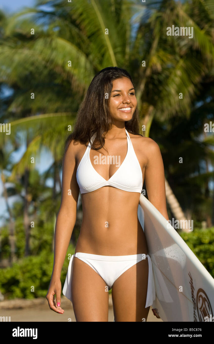 A pretty nineteen year old woman in a white bikini holds a surfboard in  Lahaina, Maui, Hawaii Stock Photo - Alamy