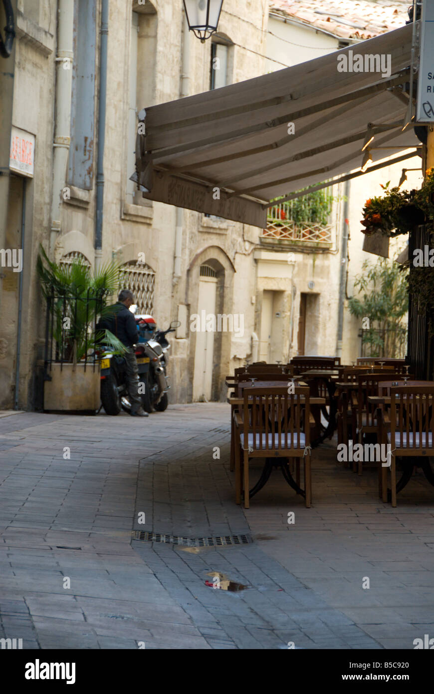 Outdoor café seating under an awning on an old street in Montpellier, France Stock Photo