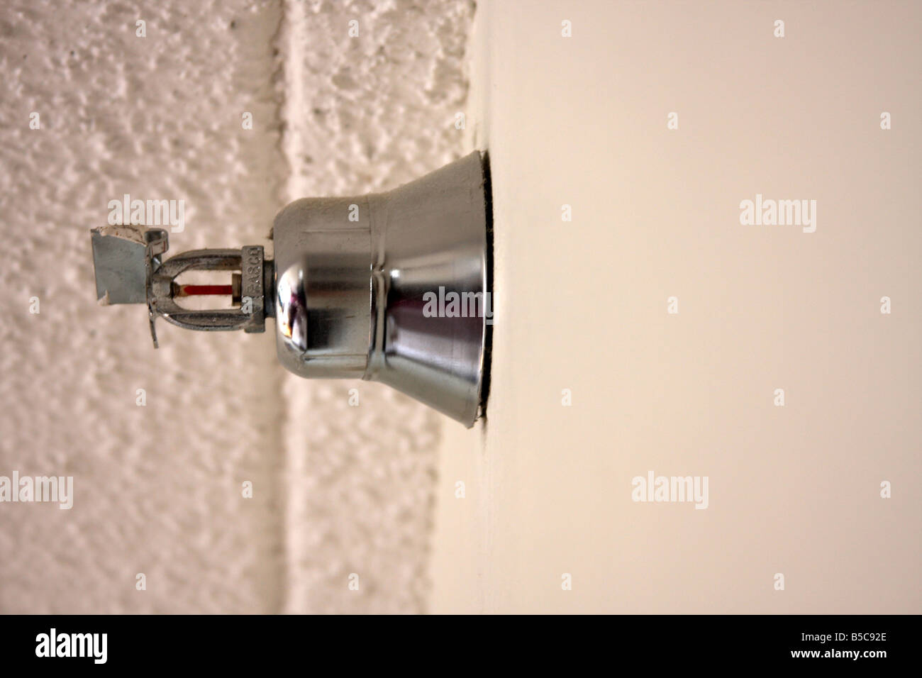 A hotel wall sprinkler in the Midwest looking at the ceiling Stock Photo