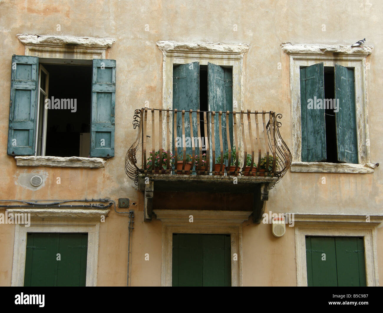 a Verona balcony with rusty railings and faded shuttered windows Stock ...