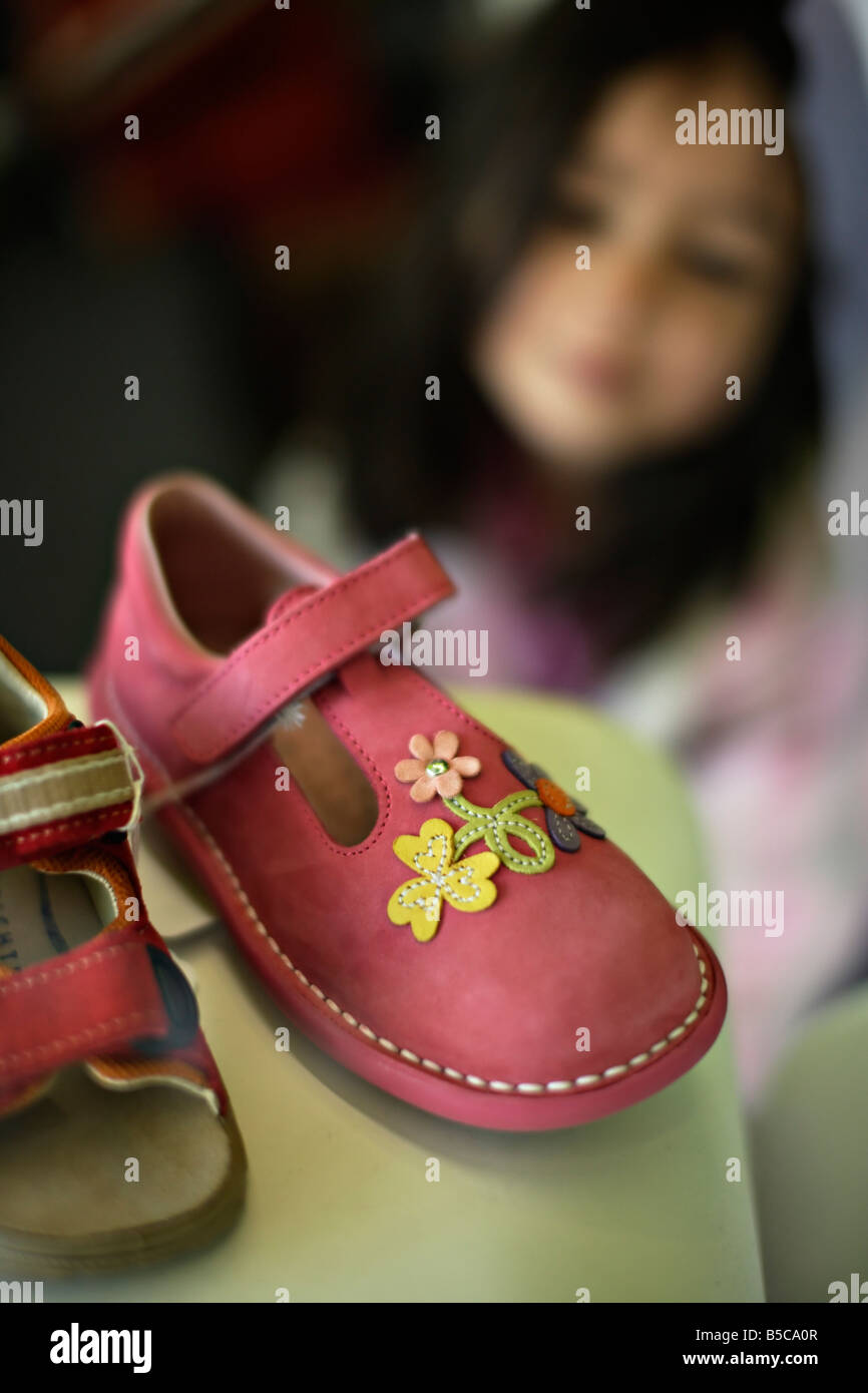 Girl six years old admires shoes in shop window Stock Photo Alamy