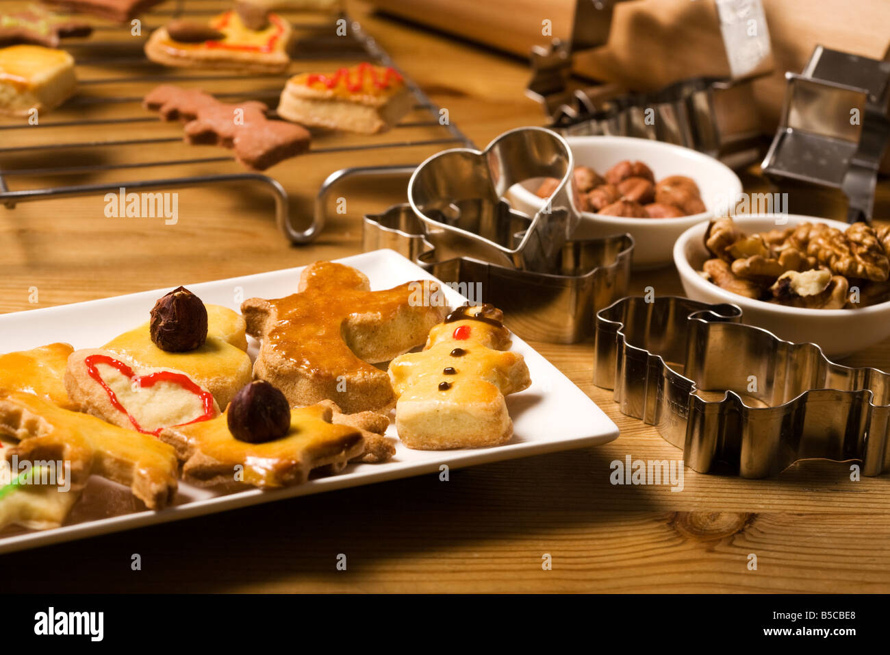 freshly made shortbread christmas cookies on a platter, baking utensils and ingredients around Stock Photo