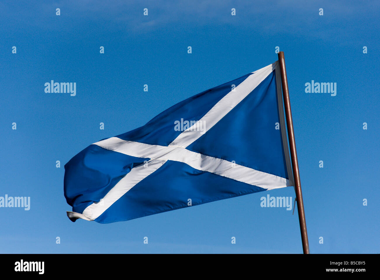 Scots flag Saltire St Andrews cross blue sky flying - direction left image may be flipped to suit layout Stock Photo
