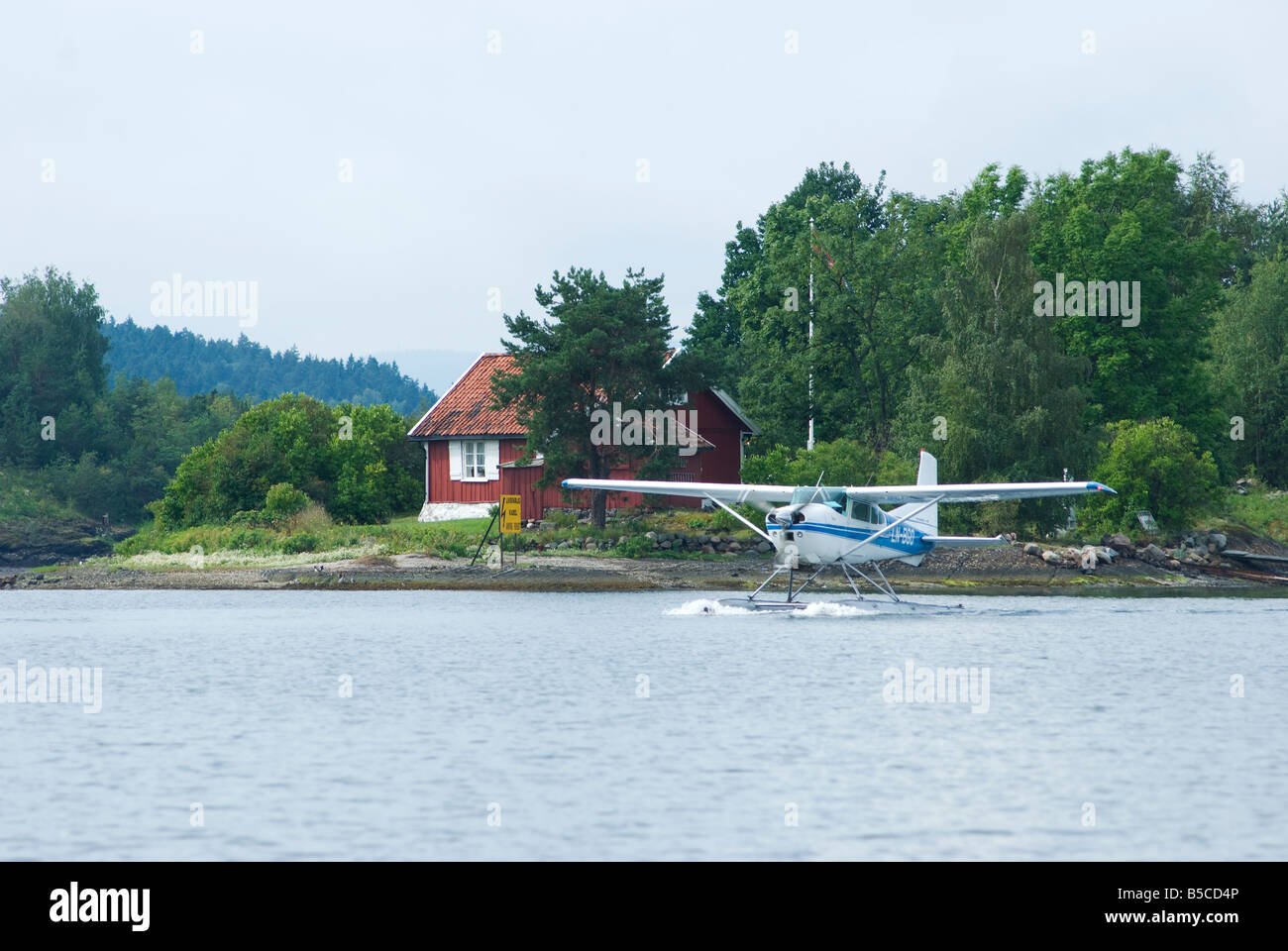 White and blue Cessna Skywagon 185 seaplane taxxiing Stock Photo