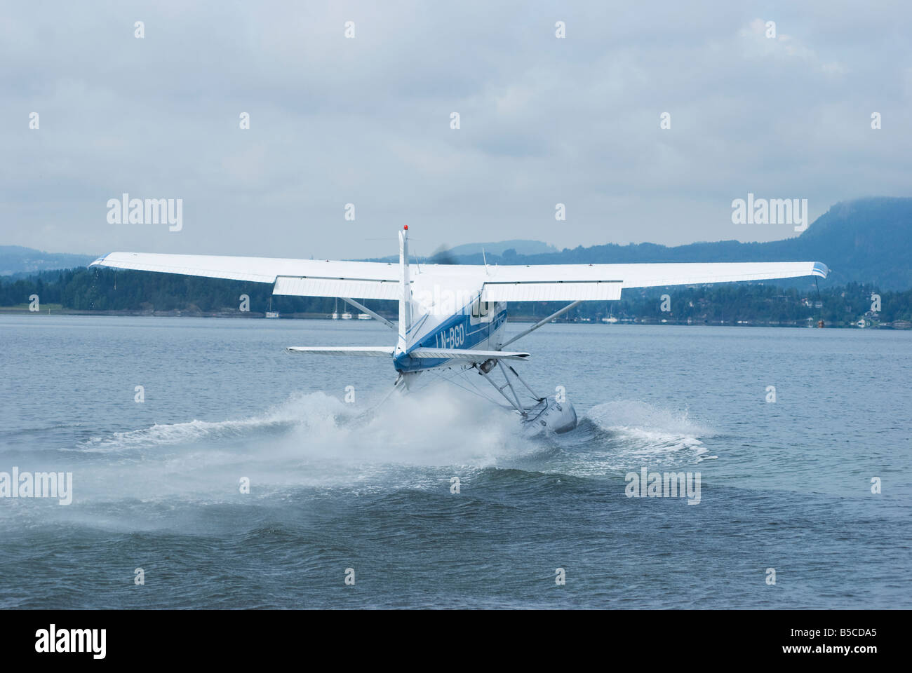 White and blue Cessna Skywagon 185 seaplane taking off Stock Photo