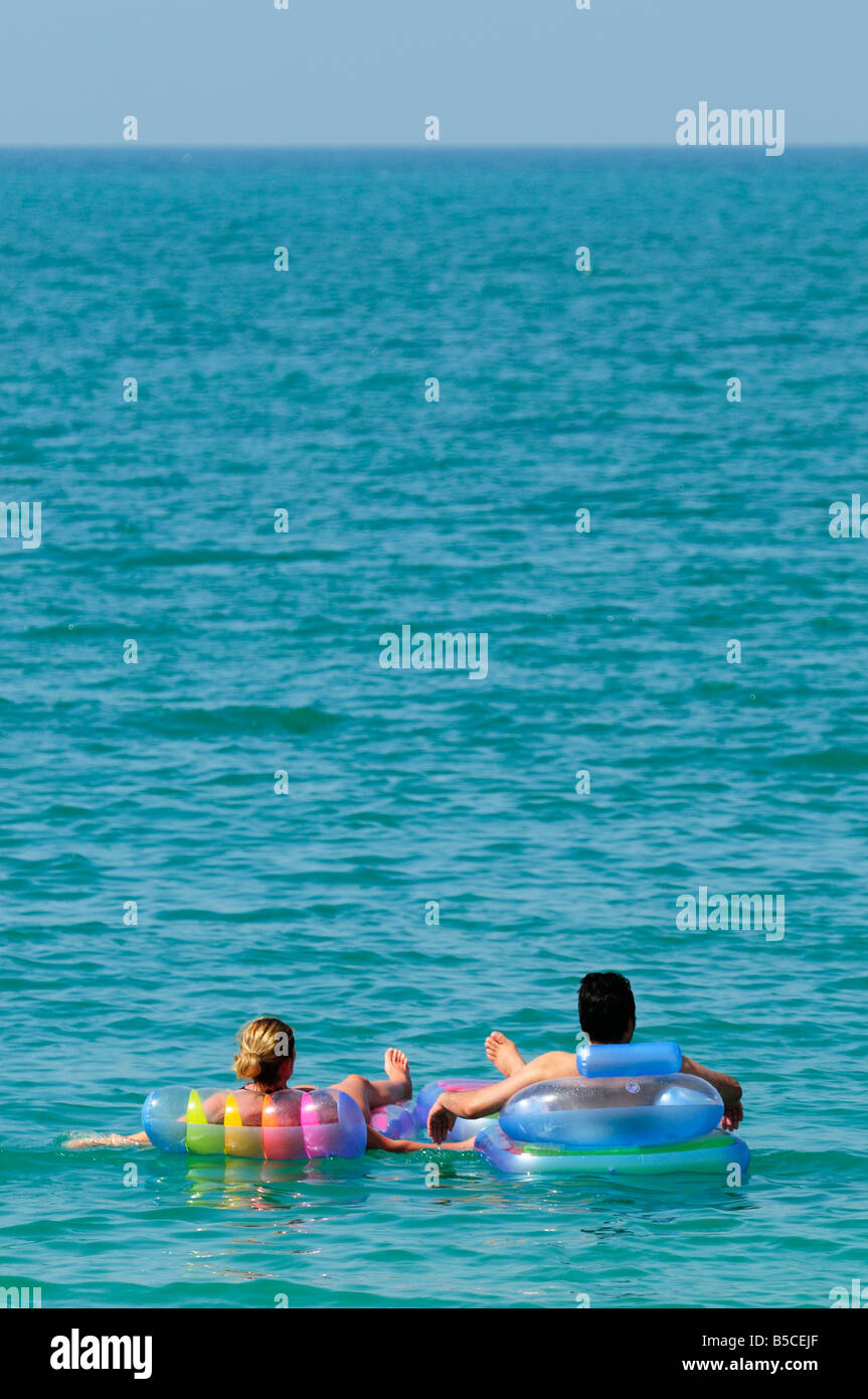 A couple on two lilos floating in the arabian ocean, Ras Al Khaimah UAE Stock Photo