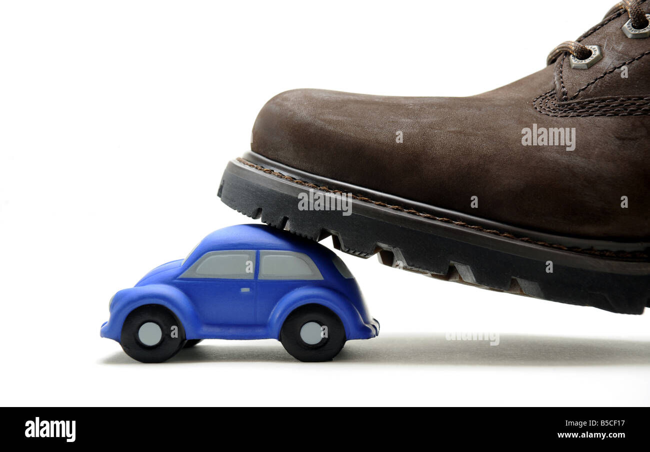 A MODEL CAR STEPPED ON BY A MANS BOOT.. Stock Photo