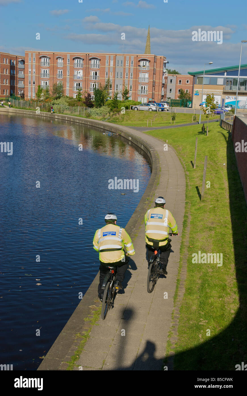Community police officers on bikes patrol the canal side at Failsworth Oldham Greater Manchester Stock Photo