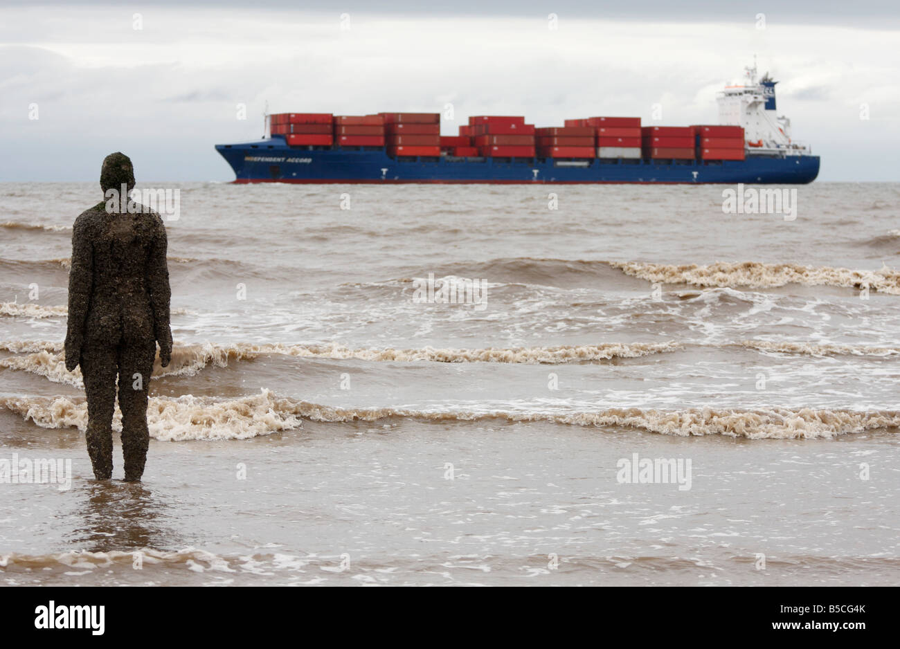 [Antony Gormley] sculpture of a man stood in sea water looking at