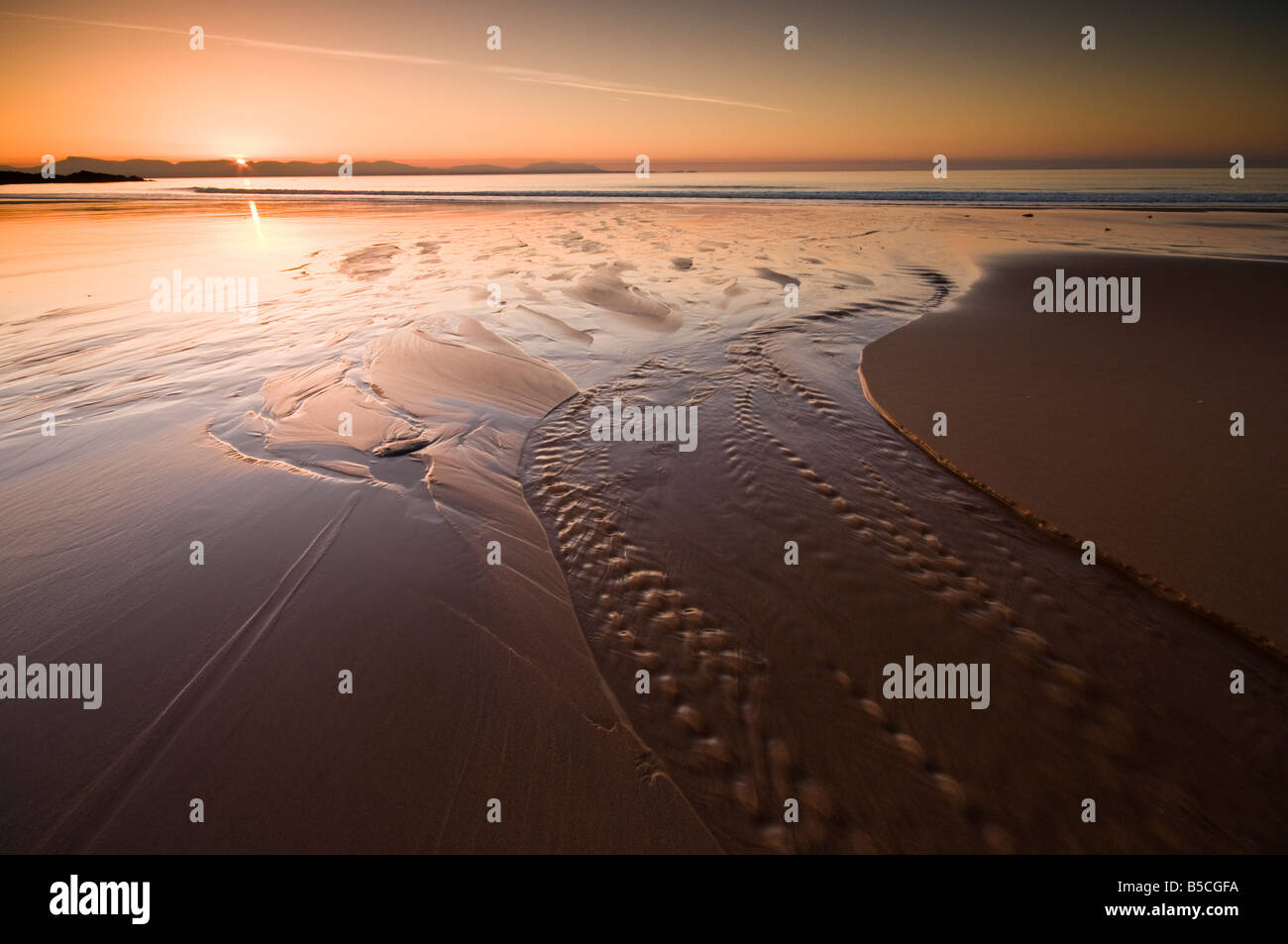 The sun sets behind the Isle of Skye as viewed from Redpoint Beach near