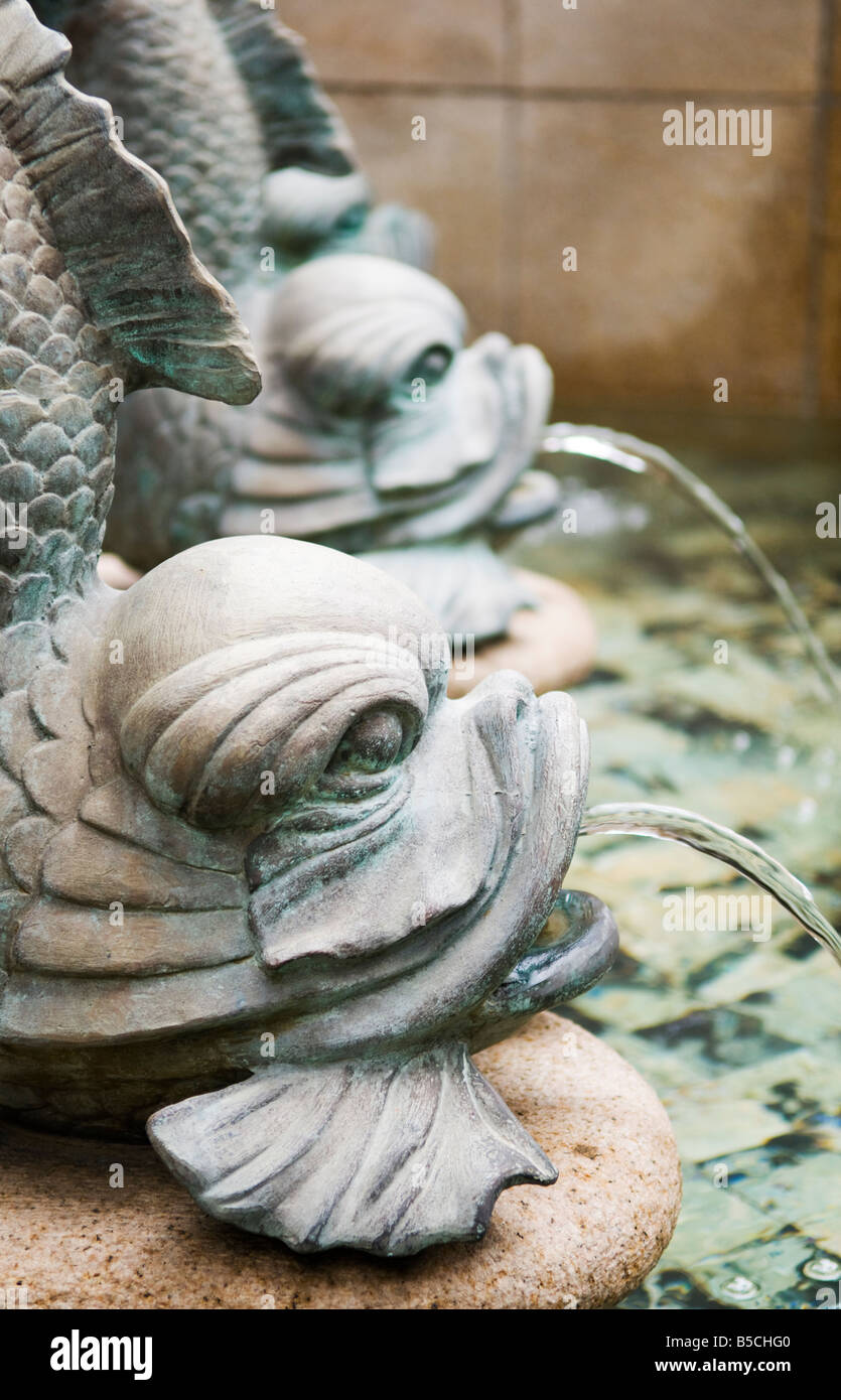 'Bronze carp fish fountains spray water into an ornate pond in a public courtyard in Hong Kong.' Stock Photo