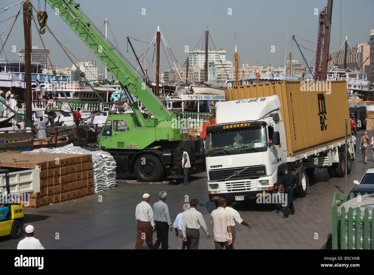 Container truck and crane loading arab dhow dubai Stock Photo