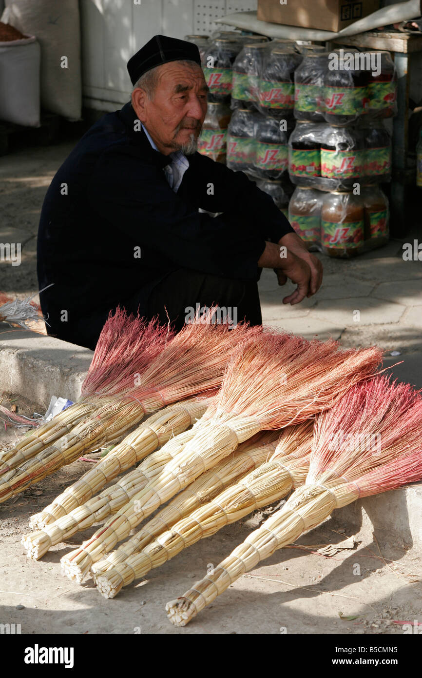 Uzbek seller of brooms in Osh market, Kyrgyzstan Stock Photo