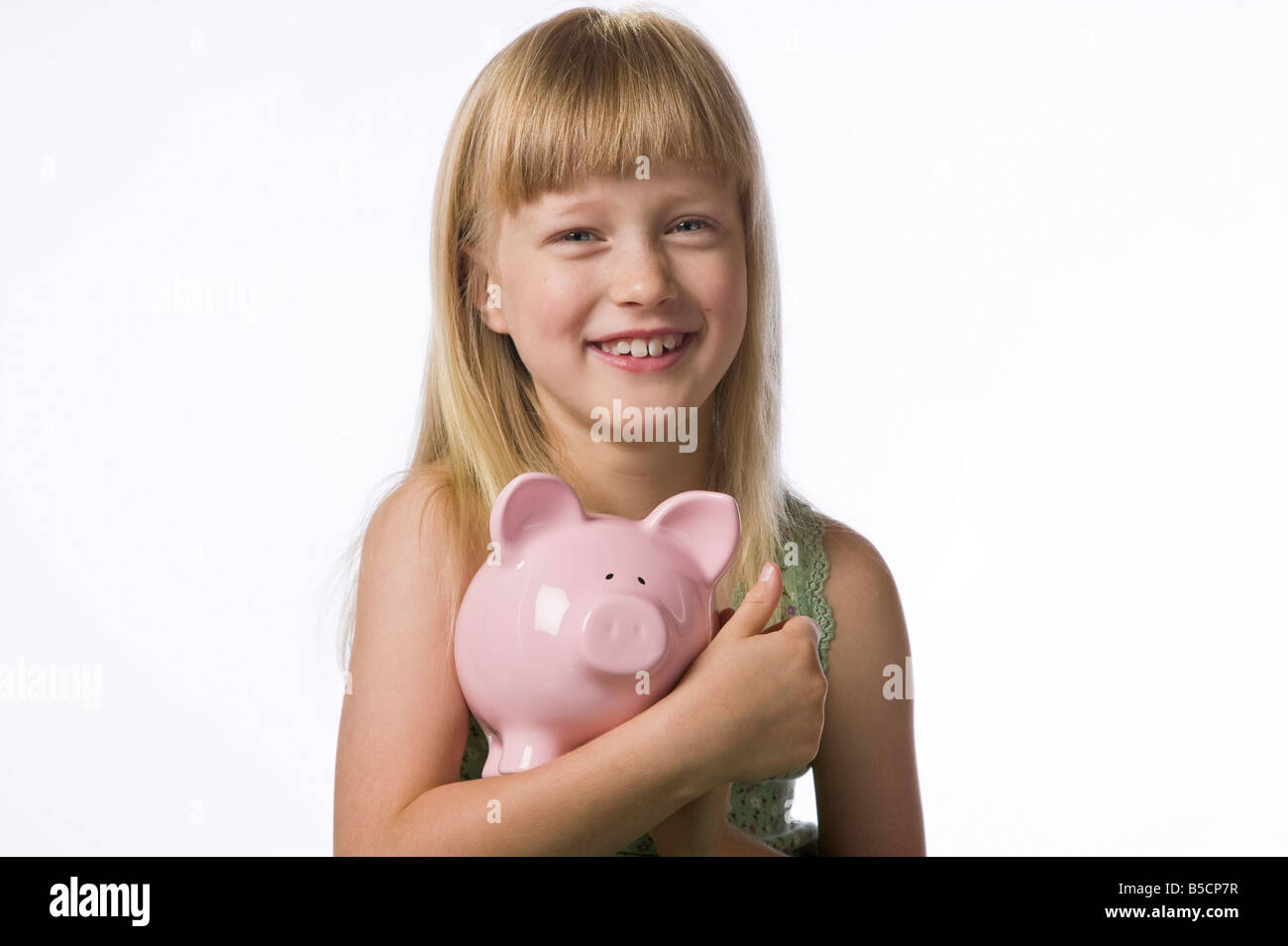 Young girl holding a piggy bank isolated on white Stock Photo - Alamy