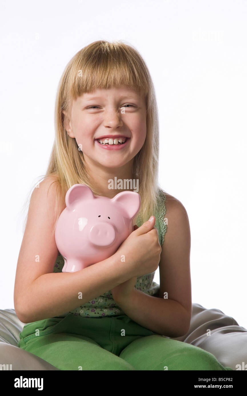 Young girl holding a piggy bank isolated on white Stock Photo - Alamy