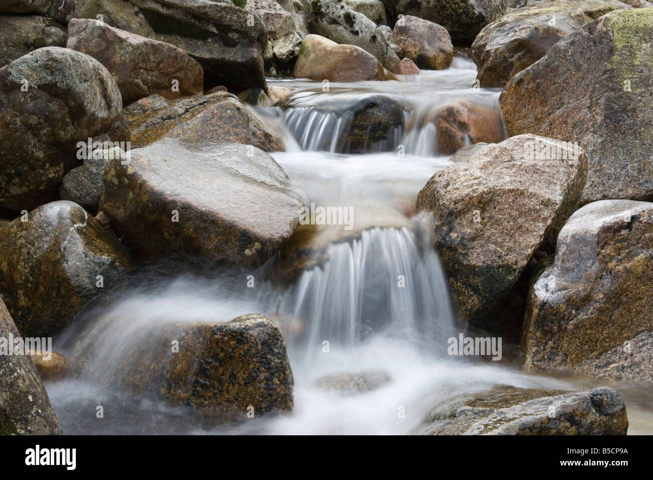 Scottish river in spate with crystal clear water tumbling over granite rocks Stock Photo