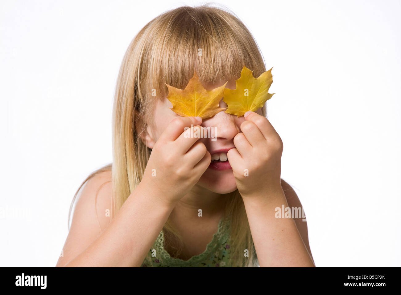 Young girl holding fall maple leaves in front of her eyes Stock Photo ...