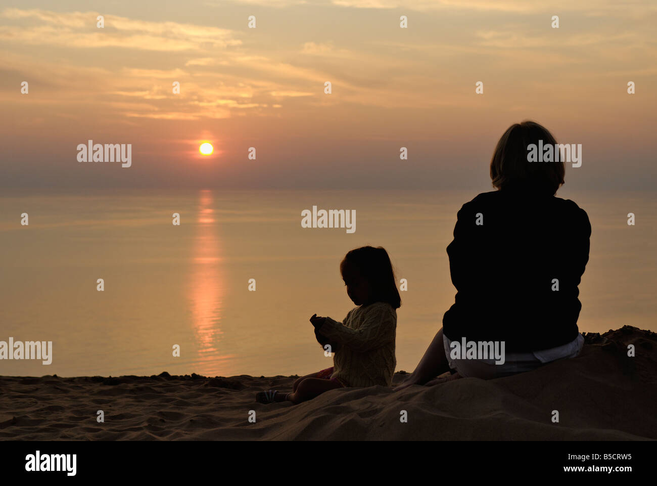 Mother and Daughter Watching Lake Michigan Sunset from Sand Dune at Sleeping Bear Dunes National Lakeshore Michigan Stock Photo