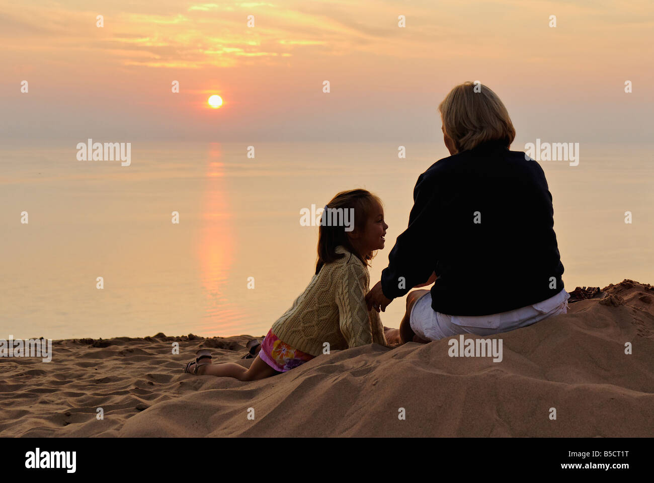Mother and Daughter Watching Lake Michigan Sunset from Sand Dune at Sleeping Bear Dunes National Lakeshore Michigan Stock Photo
