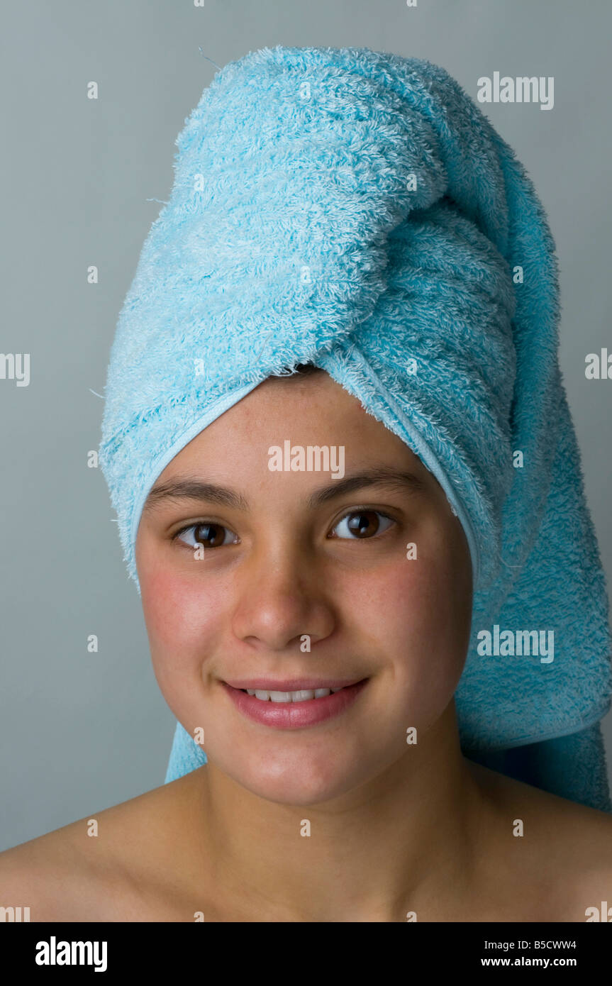 Pretty young teenager with head wrapped in a towel after washing her ...