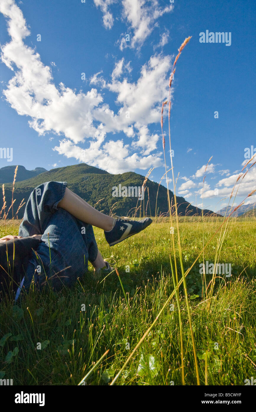 Woman laid down in the grass in a sunny day at Esquel, Patagonia, Argentina Stock Photo