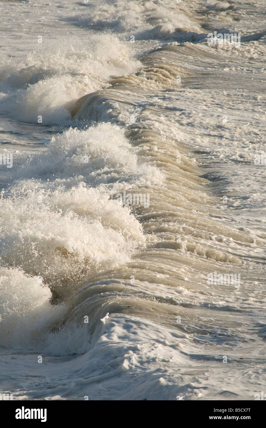Storm driven waves high wind and gales stormy weather crashing on the shore in a storm Stock Photo