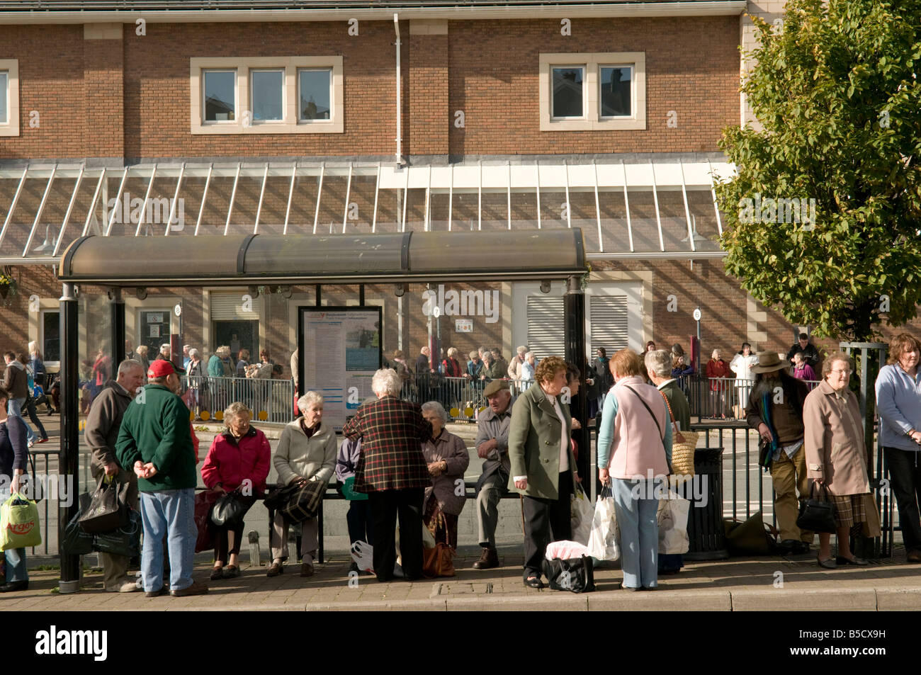 groups of People, passengers,  waiting for their buses at Carmarthen town centre bus station, Wales UK Stock Photo