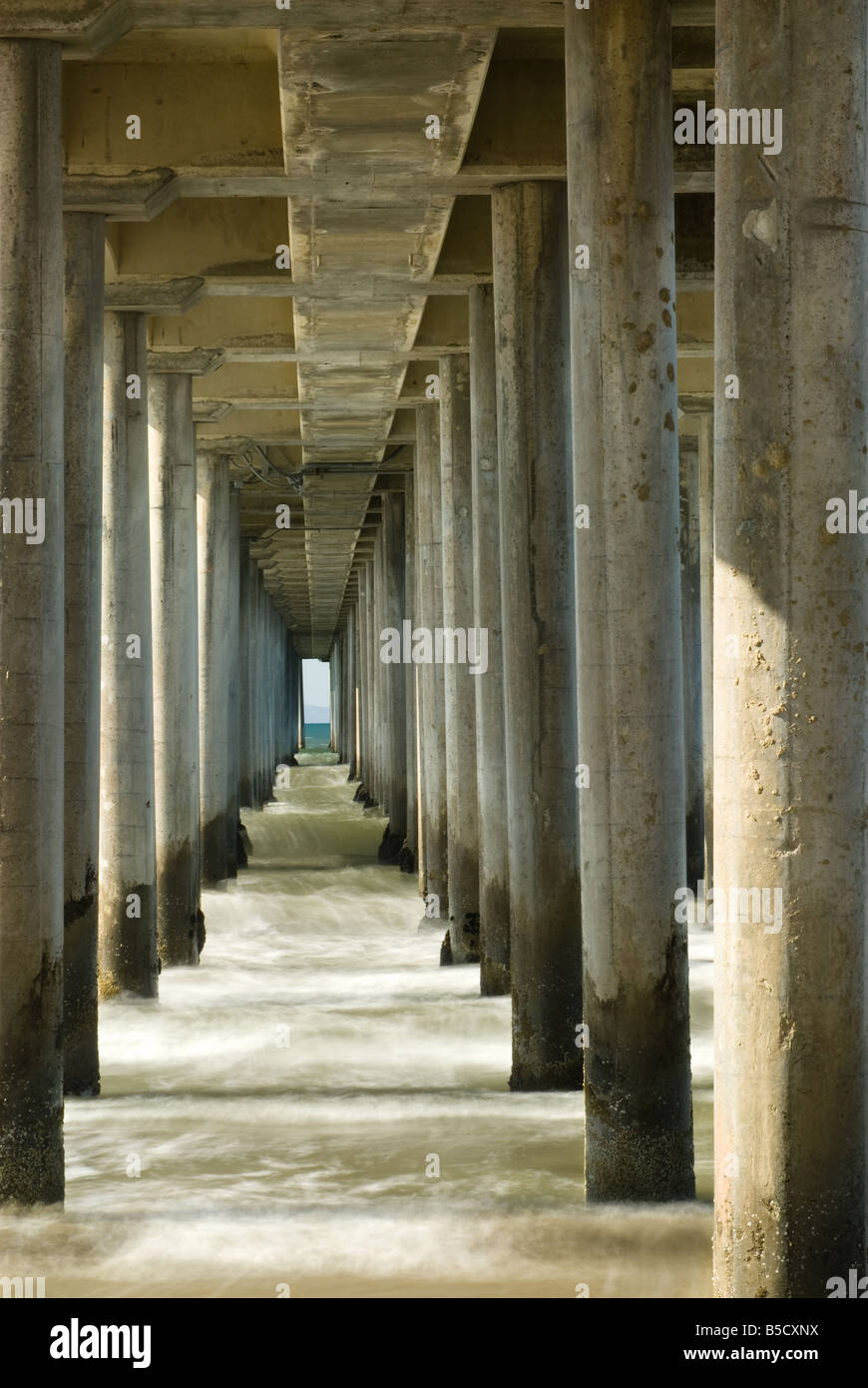 This is an image looking straight through the pilings of a pier Stock Photo