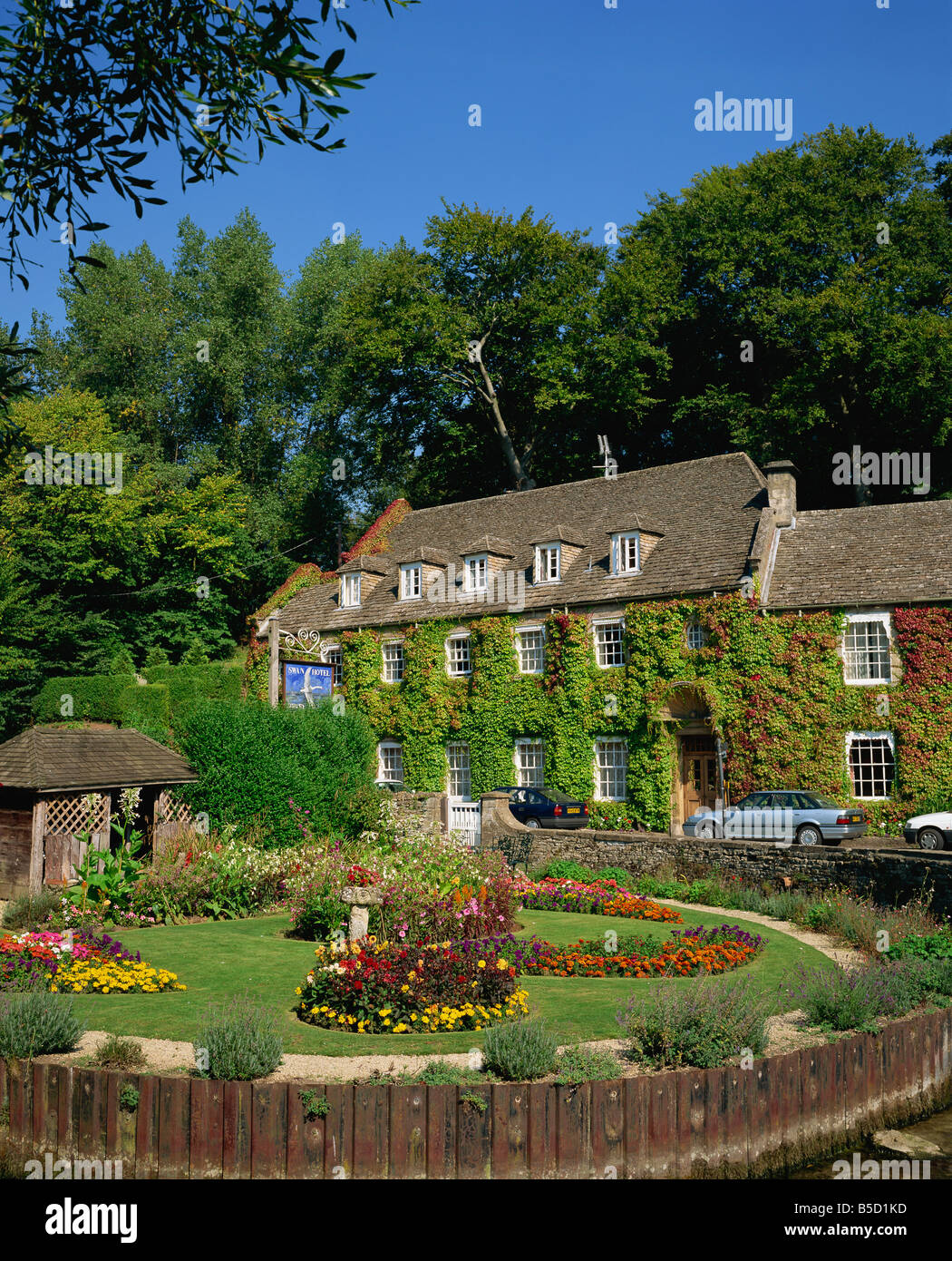 The Swan Hotel and garden full of summer flowers at Bibury in the Cotswolds Gloucestershire England R Rainford Stock Photo