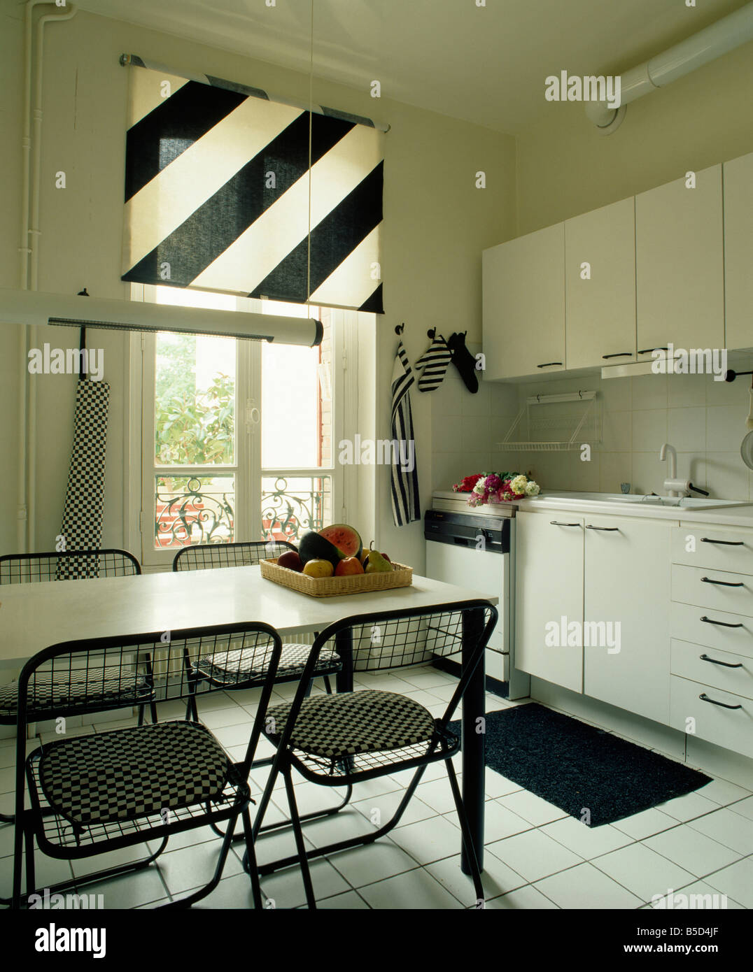 Black & white diagonally striped blind in modern white kitchen with ...