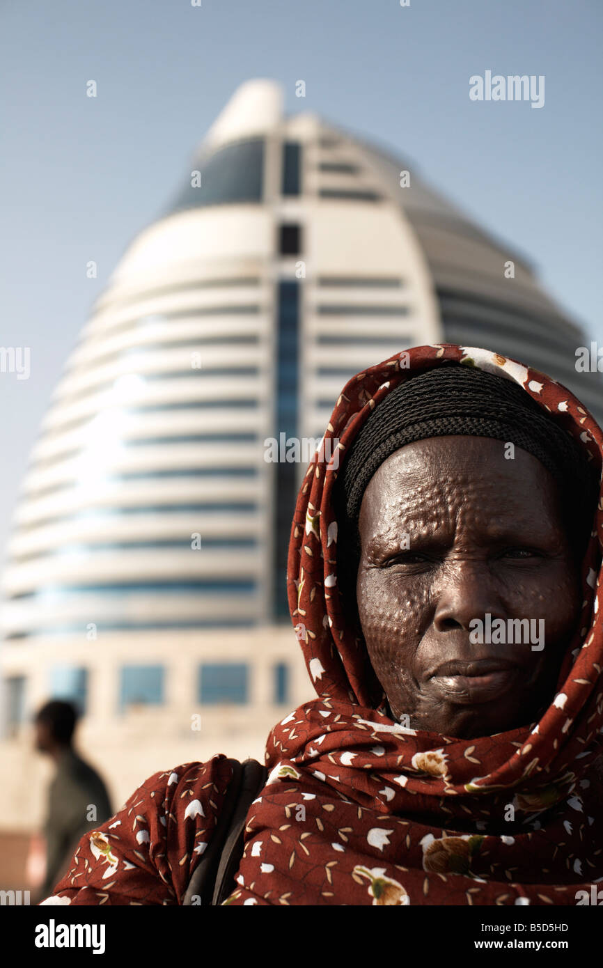 South Sudanese woman bearing tribal scarification markings, in front of the 5-star Boji Al-Fateh Hotel, Khartoum, Sudan Stock Photo