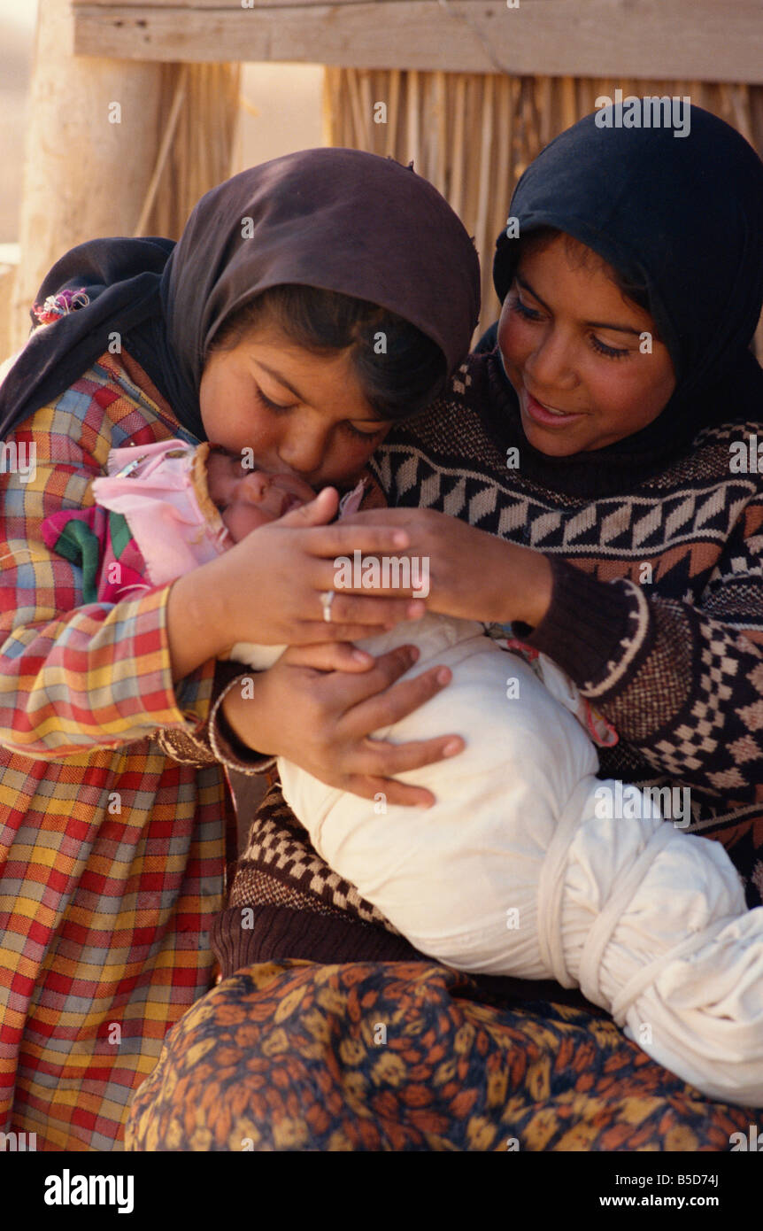 Bedouin children with newborn baby in swaddling cloth Syria Middle East