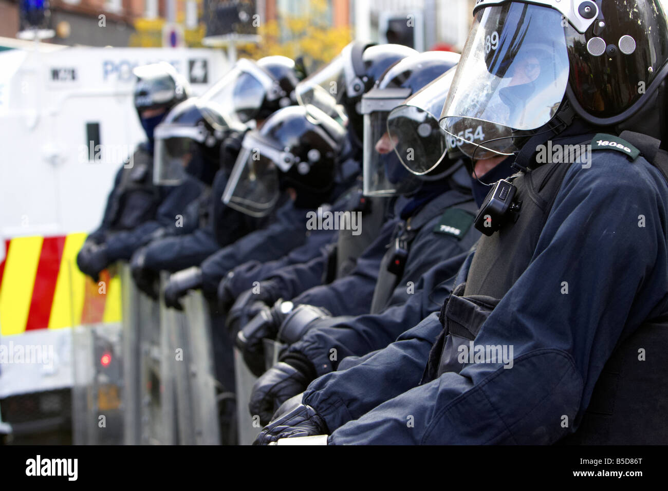 line of PSNI Police Service of Northern Ireland riot officers at ease with riot shields during disturbance belfast city centre Stock Photo