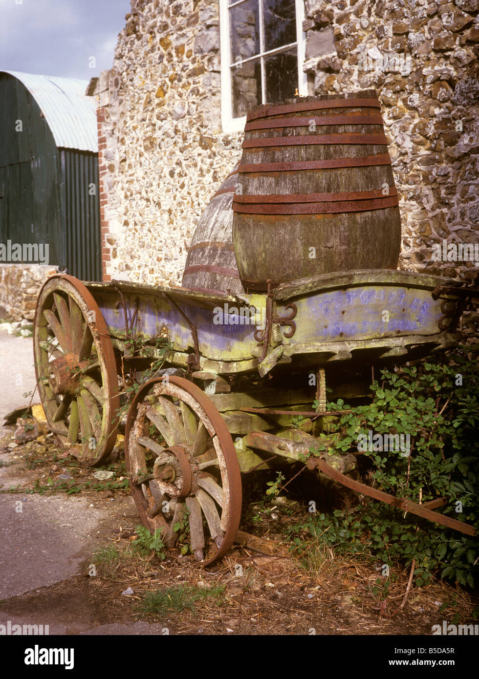 UK England Devon old cider barrels and cart in farmyard Stock Photo