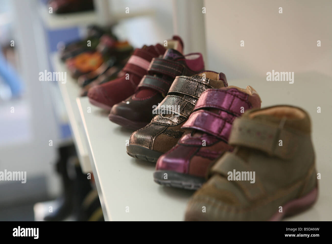 some children's shoes lined up on a shelf next to each other Stock Photo -  Alamy