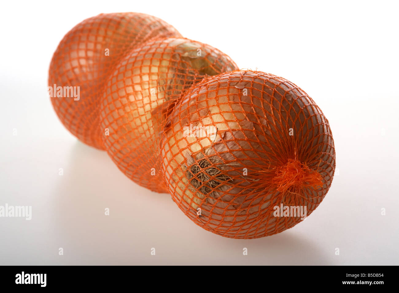 three large spanish onions in net packaging Stock Photo