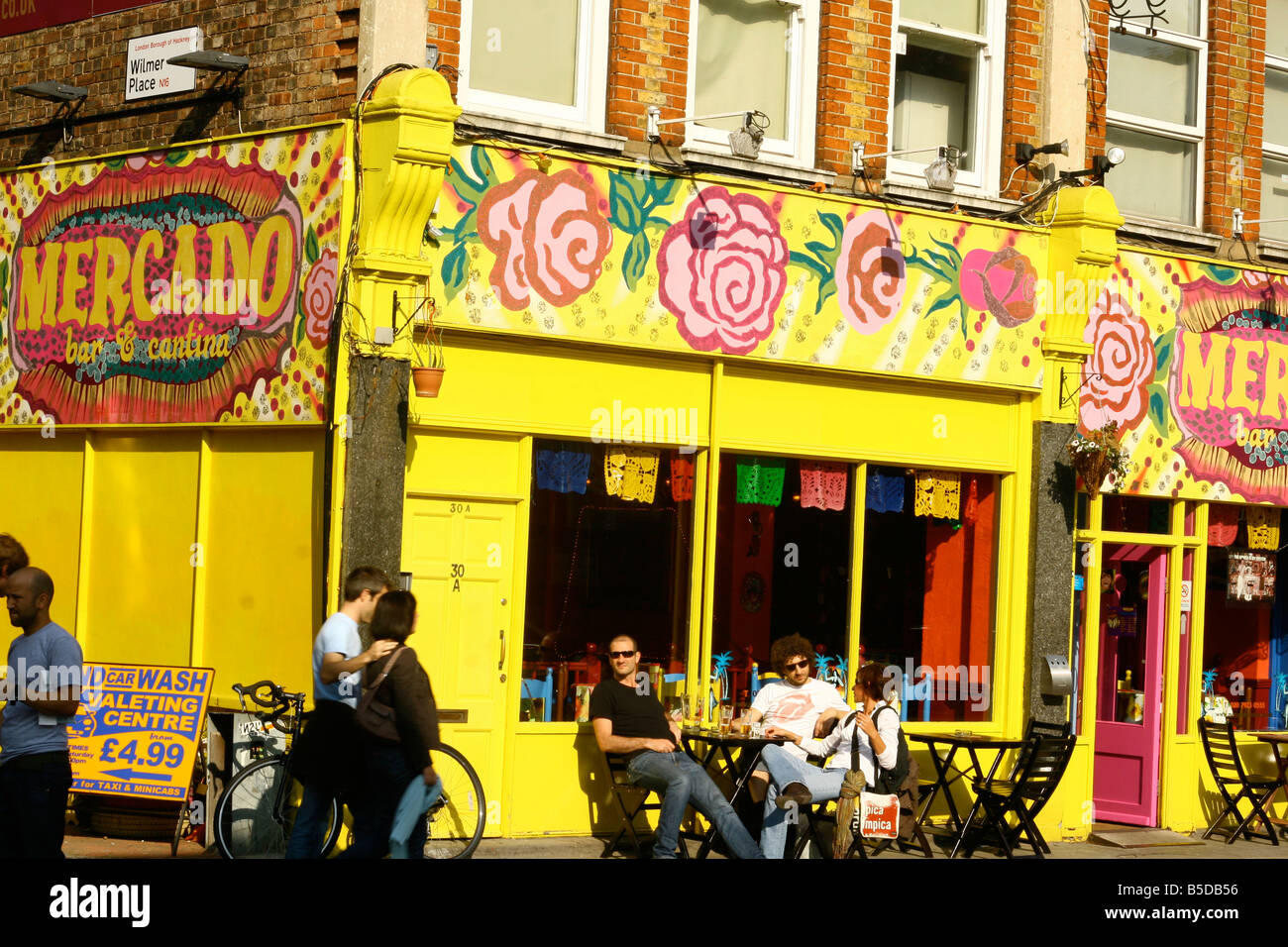 People sitting at a table outside a cafe, Hackney, London, England, UK Stock Photo