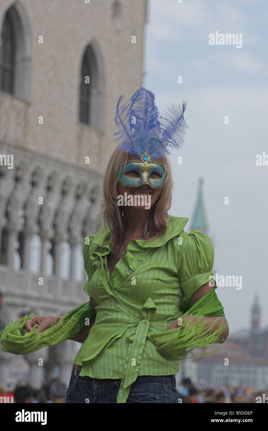 Woman in Venetian mask in front of Doges Palace, Venice Stock Photo