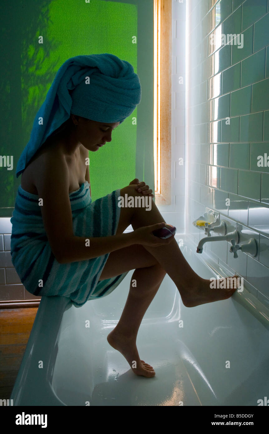 A young girl using an electric razor to shave her legs Stock Photo Alamy