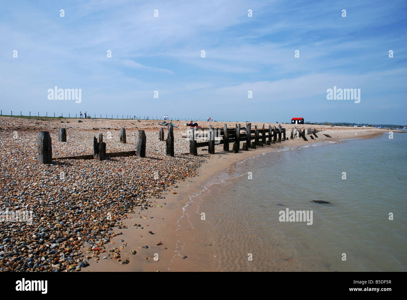 A scene showing an old wooden fence at the water's edge on Rye Harbour Nature Reserve, East Sussex, UK. Stock Photo