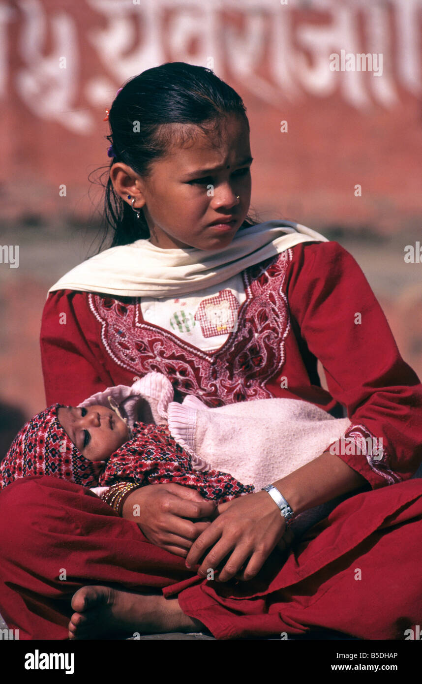 In Durbar Square, Kathmandu, Nepal, a young girl dressed in bright red