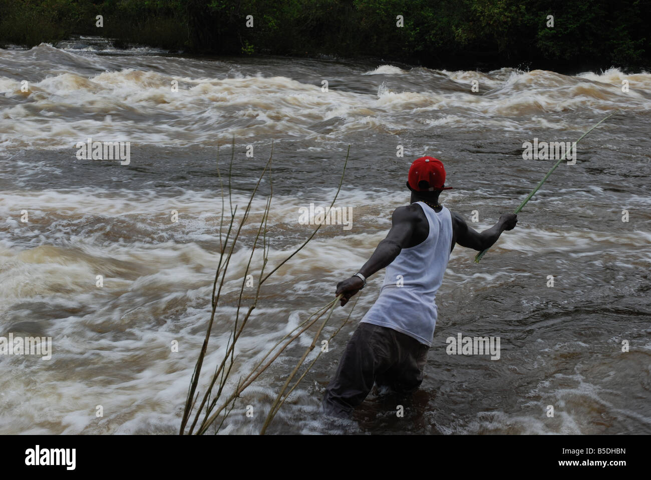 black man fishing in tempestuous white wild water Tapanahoni river Surinam Stock Photo