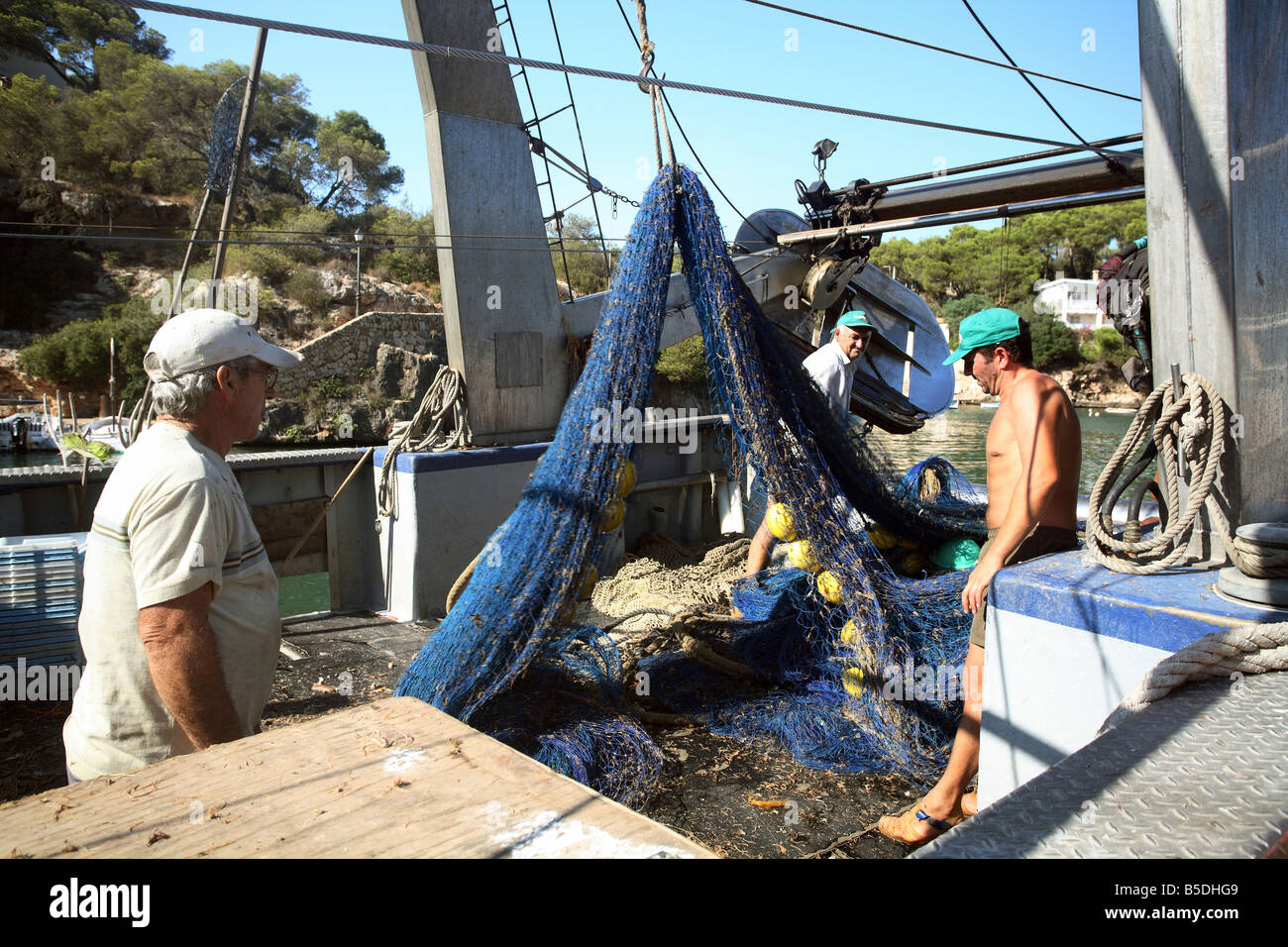 Fishermen cleaning a fishing net, Majorca, Spain Stock Photo