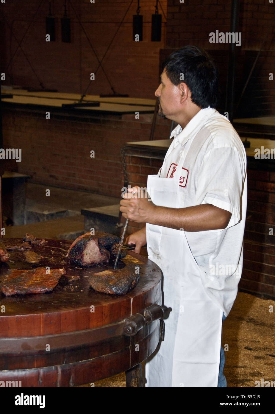 Texas Lockhart Kreuz Market barbecue smoked meat restaurant cook cutting beef brisket Stock Photo