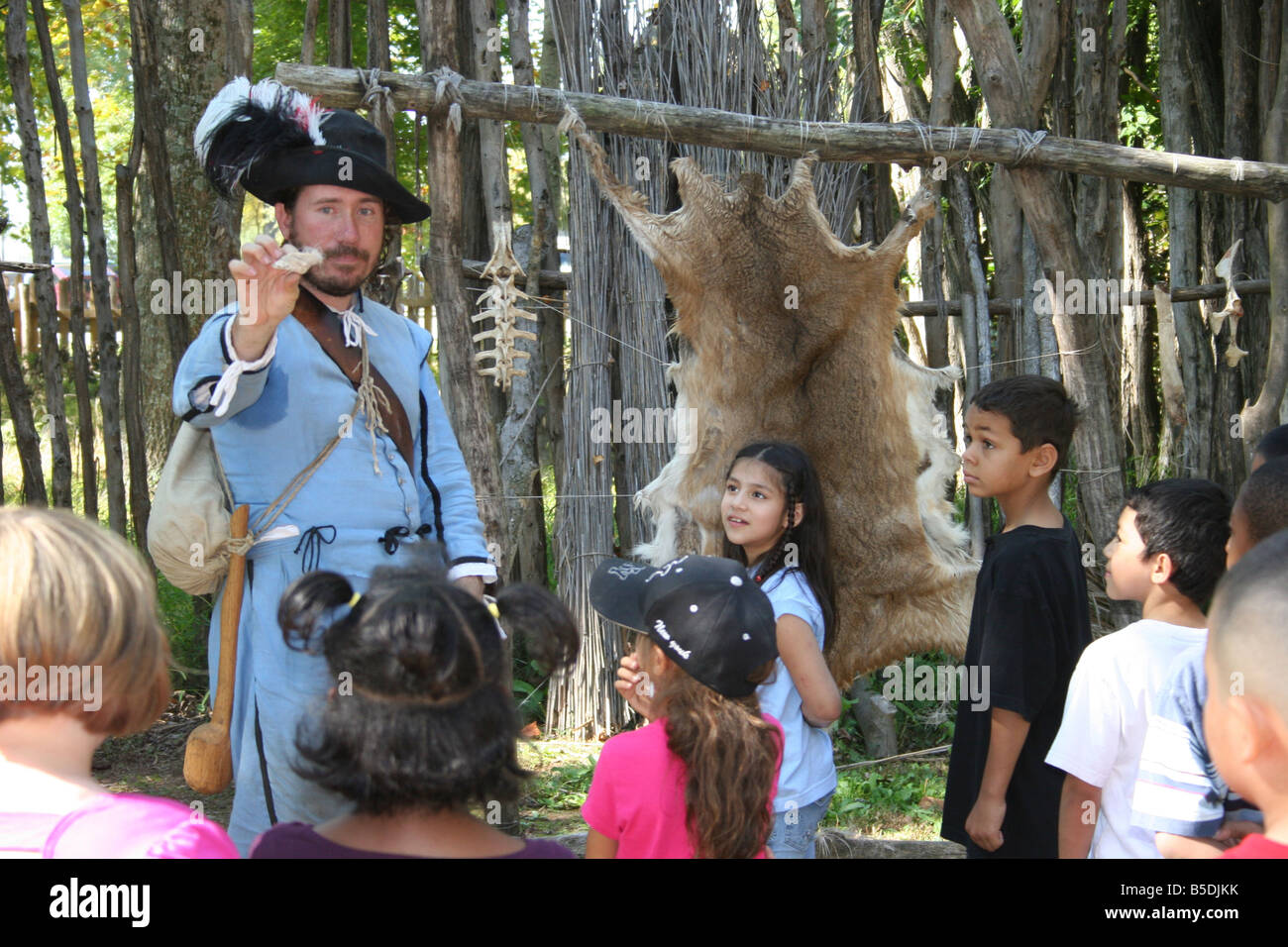 Historical interpreter showing children how food and clothing was obtained in the early 1600's at the city of  Henricus Virginia Stock Photo